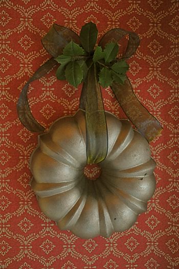 This idea isn’t anything novel but it’s still a good one. A round metal bundt cake pan takes the place of the traditional evergreen wreath. Ribbon from Micheal’s. (Photo- Martha B… Bundt Pans, Kitchen Wares, Door Hangings, Bundt Cake Pan, Easy Christmas Wreaths, Bundt Pan, Antique Kitchen, Cake Pan, Primitive Christmas