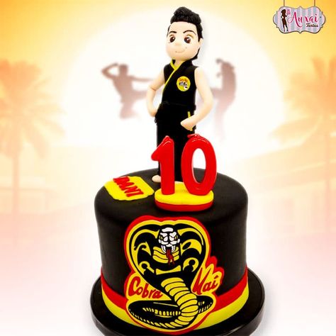 Tarta Cobra Kai. Tarta personalizada de cumpleaños, con la temática "Cobra Kai", de la serie inspirada en "Karate Kid". Sobre la tarta tenemos a nuestro protagonista, con la figura personalizada en fondant de el cumpleañero vestido con el uniforme oficial de la escuela. En el frente de la tarta hemos puesto el logo característico de Cobra Kai. Cobra Kai Cakes, Cobra Kai Cake Ideas, Cobra Kai Birthday Cake, Cobra Kai Birthday Party Ideas, Cobra Kai Birthday Party, Dragonball Z Cake, Karate Cake, Snake Cakes, Fondant People