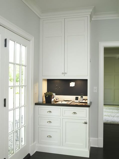 Kitchen message center features white cabinets paired with black countertops and chalkboard backsplash. Kitchen Message Center, Kitchen Desk Areas, Message Center, Kitchen Desks, Black Countertops, Mud Room Storage, Command Center, Transitional Kitchen, Kitchen Redo