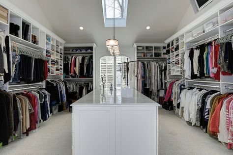 A massive walk-in closet with lots of open storage, showcasing the array of clothes and other items in the room. This much clothing could be overwhelming with all the different colors and textures, and to help tone it down, the cabinets and the rest of the room are all white. There’s a combination of hanging racks and open shelves,  creating a good variety of storage for all your needs. It also has a large island counter in the middle which also has more drawer &  cabinet storage. Small Master Closet, Walk In Closet Ideas, A Walk In Closet, Master Closet Design, Closet Small Bedroom, Closet Island, Grand Dressing, Dressing Design, Dressing Room Decor