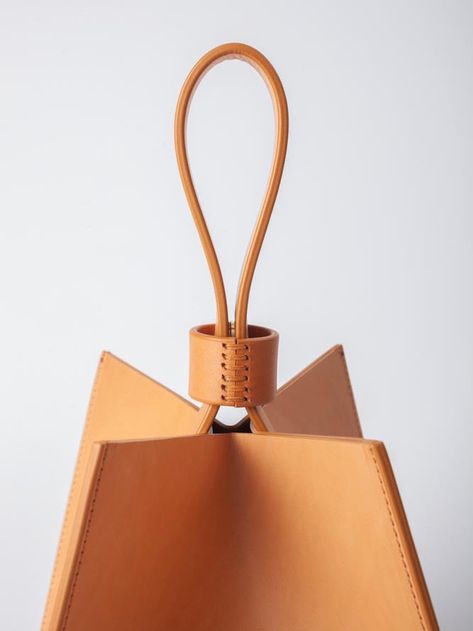 The Cube handbag is a pleasure to carry in your hand or on your wrist. The structural, unique cube shape offers spacious storage and boasts a hidden magnetic closure embedded in its handle. The 100% Veg-tanned Vachetta leather bag is intentionally unlined. Crafted with skill by artisans in the Arrhe Studios workshop in Fano, Italy. FIT & SIZING Dimensions: 8" x 8" x 8" DETAILS Fabric | 100% Veg Tanned Vachetta Italian LeatherColor | NATURALDesigner | ARRHE STUDIOS CARE The leather chosen is subj Luxury Bags With Leather Handles For Gifts, Studio Bag, Cube Shape, Unique Handbags, Colorful Handbags, Colorful Bags, Original Fashion, Bag Clips, Unique Bags