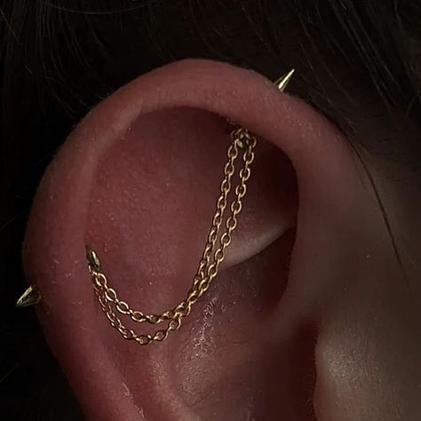 Hazel 🌷 on Instagram: "Chains , Spikes and Springy leaves 🧡 Awesome upgrade for Kirsty for piercings long healed. Awesome spikes in the industrial from @junipurrjewelry paired with the Florence in yellow gold for the lobes! Topped off with a custom double industrial chain made by me ⭐ So fun!!!! Thank you for the trust! #ukbodypiercer #earcuration #earstyling #earchains #scottishpiercer #edinbrughpiercer #styledear" Industrial Piercing With Chain, Piercings Ear Industrial, Ear Piercings With Industrial, Double Industrial Piercing, Jacob's Ladder Piercing, Chain Industrial Piercing, Industrial Piercing Chain, Edgy Piercings, Chain Industrial