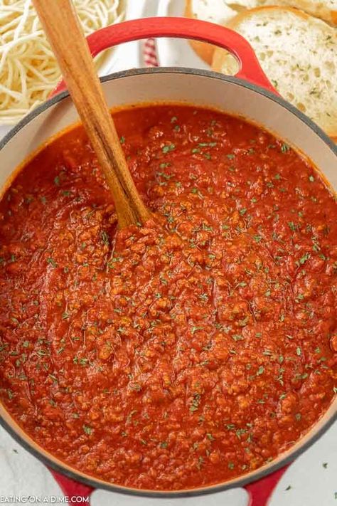 Close up image of spaghetti sauce in a dutch oven with a wooden spoon. Dutch Oven Spaghetti Meat Sauce, Dutch Oven Spaghetti Sauce, Oven Spaghetti Sauce, Freeze Spaghetti Sauce, Dutch Oven Spaghetti, Freeze Spaghetti, Bolognese Recipes, Ground Beef Spaghetti Sauce, Pressure Cooker Spaghetti