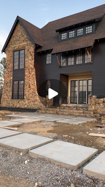 Exteriors Of Instagram on Instagram: "Bold meets natural elegance: This home’s exterior, a symphony of black siding and rustic stone.  @idealhome2024  @thehighlandsneighborhood @b_k_build  @brogdonproperties   @gbahb_  @themaebethdesigns   #birminghamparadeofhomes #newconstruction #homeexteriordesign" Black And Stone Farmhouse Exterior, Stone And Dark Siding Exterior, Black Siding Exterior With Brick, Brown Stone Exterior House, Brick And Rock House Exterior Farmhouse, Exterior House Colors With Brick, Dark Brick And Stone Home Exterior, Stone Exterior Houses, Black Brick