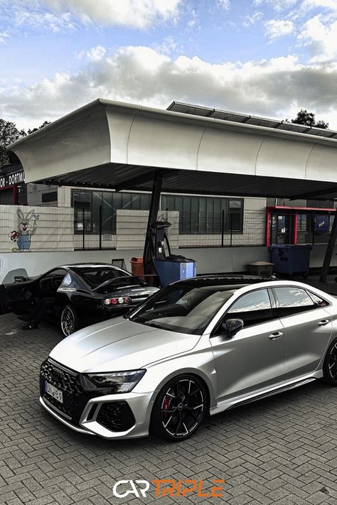 Audi RS3 parked in front of a building with a black sports car in the background. Audi A3 Sedan, Dream Whip, Audi Rs3, Hot Hatch, Audi Sport, Audi Rs, Audi Cars, Dream Garage, Audi Tt