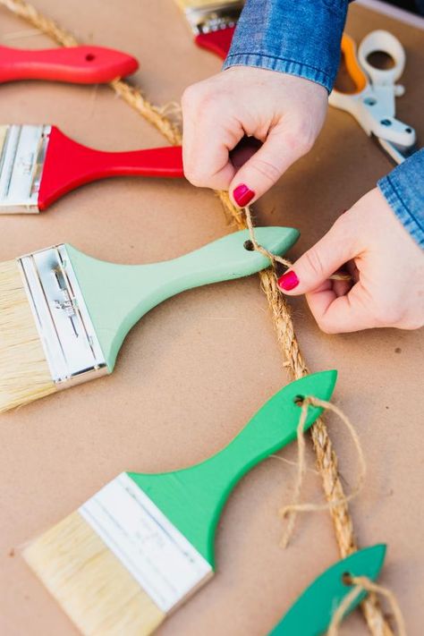 The holiday experts at HGTV.com share an easy tutorial for creating a festive paintbrush garland to decorate your porch. Art Theme Decoration Ideas, Art Room Window Decor, Art Party Decorations Ideas, Paintbrush Chandelier, Diy Giant Paint Brush, Art Party Decorations Diy, Art Themed Classroom, What A Mess Vbs Decor, Giant Paintbrush