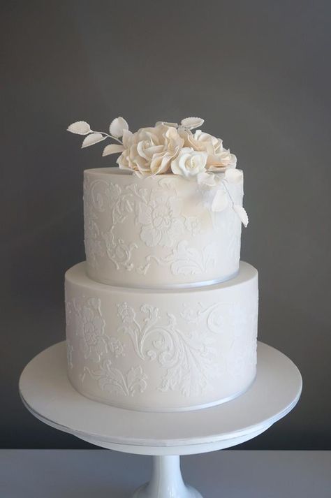 Ivory cake with white stenciling and sugar flowers . Cake Envy Melbourne Lace Stencil Wedding Cake, White On White Stencil Cake, Wedding Cake With Stencil Design, Wedding Cake Stencil Patterns, Stencil Wedding Cake Designs, Stenciled Wedding Cakes, White Stencil Cake, Stencil Wedding Cake, White Fondant Cake