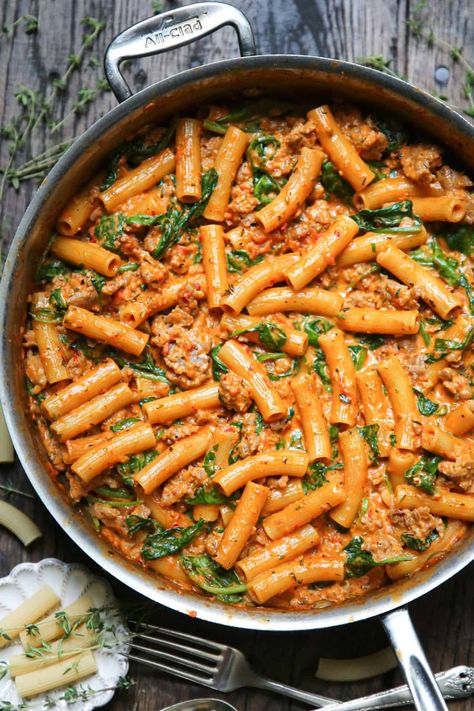 creamy sausage rigatoni with tomato sauce and spinach in a stainless steel skillet. Sausage Rigatoni Pasta, Creamy Sausage Rigatoni, Rigatoni Pasta Recipes, Rigatoni Recipe, Sausage Spinach Pasta, Spicy Sausage Pasta, Sausage Rigatoni, Rigatoni Recipes, Sausage Sauce