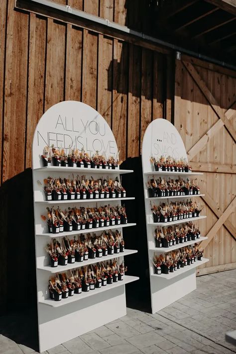 This luxe Cali wedding welcomed guests with a wall of charcuterie Charcuterie Cup Wall Display, Champagne Wall Wedding Seating Chart, Charcuterie Wall Display, Chip Wall, Wedding Snack Wall, Charcuterie Cup Wall, Charcuterie Cup Display, Charcuterie Wall, Arch Drink Wall