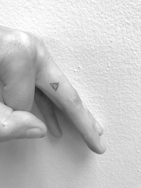 Deathly Hallows symbol tattoo on the left finger. Deathly Hallows Tattoo Finger, Slytherin Tattoo Minimalist, Minimal Harry Potter Tattoo, Microtattoo For Women, Harry Potter Minimalist Tattoo, Harry Potter Tattoos Minimalist, Minimalist Harry Potter, Tiny Harry Potter Tattoos, Slytherin Tattoo