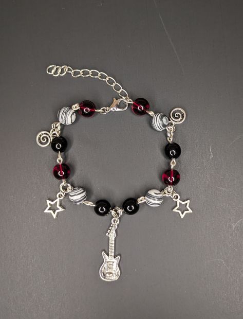 This bracelet is made with red, black and white and black beads, a guitar charm, star charms and spiral charms! The bracelet measures to 7in plus a 2in extender! If you are interested in the bracelet and need it to be a different size feel free to message me and I could make it a custom length! Black Star Bracelet, Cute Black Clothes Outfits, Red Black White Bracelet, Rockstar Gf Bracelet, Tom Boy Jewelry, 2000s Bracelets Aesthetic, Jewelry Inspo Bracelets, Grunge Jewelry Bracelets, Red And Black Bracelets