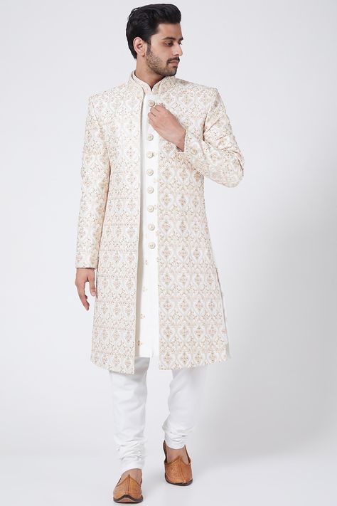 Featuring a white open jacket in raw silk base with thread, sequins, and zari embroidery. It is paired with contrasting churidar pants in cotton silk base and sherwani having a mandarin collar.    FIT: True to size.  COMPOSITION: Raw silk, Cotton silk.  CARE: Dry clean only. Weeding Outfits For Boys, Machine Work Embroidery, Wedding Dress For Boys, Embroidery Dress Designs, Open Sherwani, Indo Western Outfits For Men, Wedding Matching Outfits, Indian Wedding Suits Men, Man Dress Design