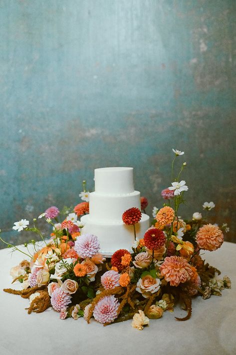 Bright Flower Wedding Cake, Flowers Around Wedding Cake, Muted Colorful Wedding, Bright Fall Wedding Flowers, Flowers Around Cake, Fall Elegant Wedding, August Wedding Ideas, Cake Table Flowers, Palace Photoshoot