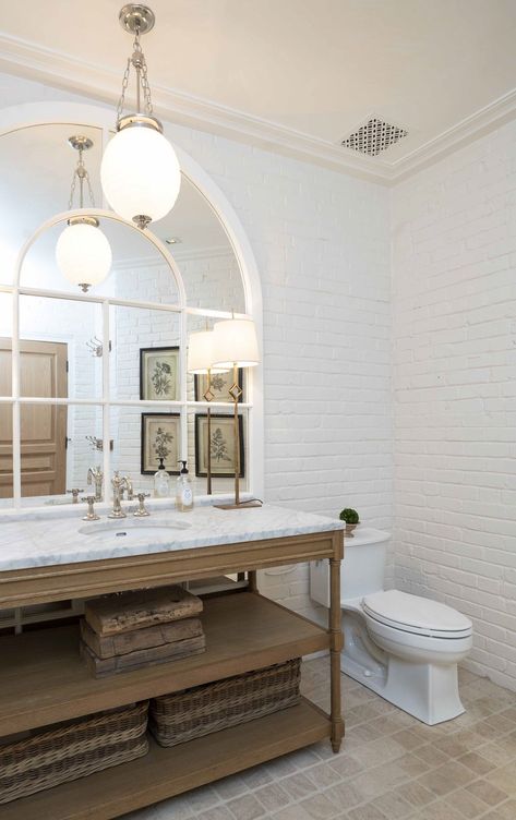 What an absolutely stunning bathroom! This European farmhouse style bathroom is incredible. With white brick walls paired with a warm wood vanity and marble countertops, we are in love. #bathroom #bathroomremodel #bathroomideas #homeremodel #customhome #homeinspo #remodel White Brick Bathroom Wall, White Brick In Bathroom, Modern European Farmhouse Bathroom, Bathroom Tiles Farmhouse, White Brick Floor Bathroom, White Brick Bathroom Floor, Powder Room With Brick Floor, White Brick Wall Bathroom, Rustic European Bathroom