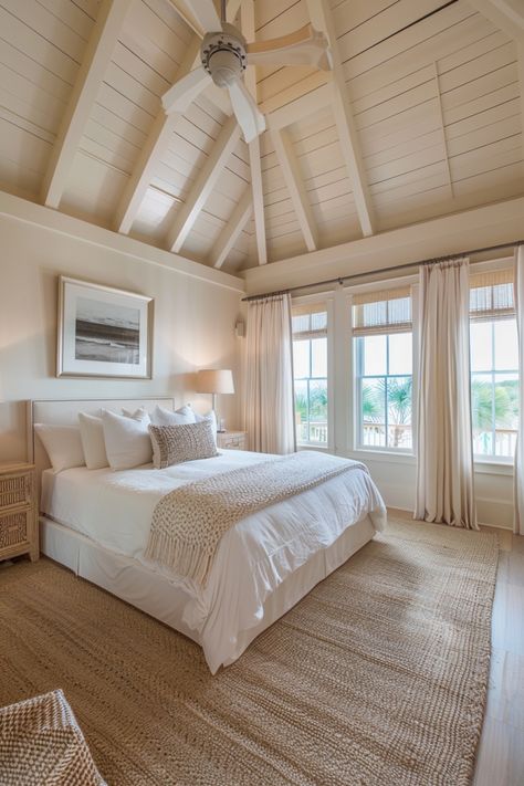 Cozy bedroom with white bedding, wooden ceiling fan, large windows, and beach-inspired decor. Coastal Home Bedroom, Beach House Master Bed, Beachouse Bedroom, Beach House Master, Coastal Cottage Bedroom, Bedroom Aesthetic Ideas, Coastal Bedroom Aesthetic, Coastal Bedroom Decor, Costal Bedroom