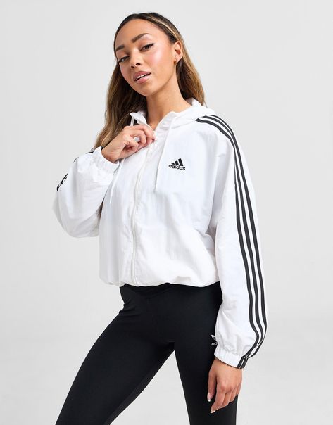 Add a retro-inspired layer to your rotation this women's Woven Lightweight Jacket from adidas. In a White colourway, this loose-fitting fit jacket is cut from smooth recycled nylon that's both breathable and water-resistant. It features a full-zip fastening and adjustable hood for custom coverage, ribbed trims to hold the shape and side pockets for secure storage. Finished up with 3-Stripes to the sleeves and a Badge of Sport to the chest. Machine washable | Our model is 5'8" and wears a size small. | IC0560 White Addidas, White Adidas Jacket, Sport Logos, Chest Machine, Woman Weaving, Jacksonville Jaguars, White Jacket, Jd Sports, Workout Jacket