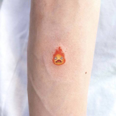 Small Calcifer Tattoo, Calcifer Howl Tattoo, Yechan Lucy, Calcifer Art, Lucy Tattoo, Tattoos Between Breast, Calcifer Tattoo, Howls Moving Castle Tattoo, Tatuaje Studio Ghibli