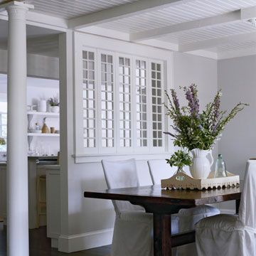 Use Windows as Room Dividers  A bank of tall and narrow multi-pane windows between the kitchen and the dining room makes both rooms feel lighter and airier.  Another transitional element, a pair of wood columns, visually separates the dining room from the adjacent living area.  Wow...what if I did away with the breakfast bar and installed storage cabinets with a set of windows above?! Half Wall Room Divider, Room Divider Headboard, Small Room Divider, Temporary Room Dividers, Metal Room Divider, Fabric Room Dividers, Portable Room Dividers, Bamboo Room Divider, Sliding Room Dividers