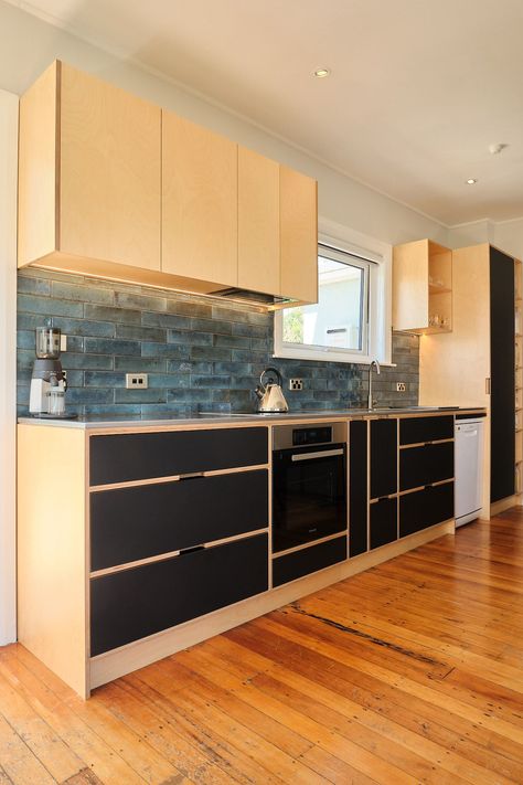 This kitchen is designed using inset style joinery, where the entire cabinetry is built as one unit, using 18mm/13ply birch plywood for the cabinets and a matt black laminate for the faces. Notice how the handles are cut-outs on the horizontal stretchers in between the drawers, creating a clean and contemporary look. #plywood #kitchen #lowerhutt Kitchen Plywood Color, Wall Cupboards Design, Modern Rustic Kitchen Design, Rustic Kitchen Design Ideas, Single Wall Kitchen, Modern Rustic Kitchen, Rustic Kitchen Ideas, Plywood Kitchen, Wall Cupboard