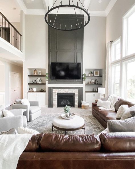 [CommissionsEarned] A Gorgeous Transitional Living Room With An Impressive Statement Fireplace, Open Shelving, And A Mix Of Leather And Neutral Seating. | Peaceandpinedesigns.Com For More #cozytransitionallivingroom Big Wall Decor Living Room Tall Ceilings Open Spaces, Large Tv Living Room, Two Story Living Room Fireplace, Tall Living Room Wall Decor, Sitting Room Ideas With Fireplace, Fireplace Tall Ceilings, Contemporary Tv Room, High Ceiling Living Room Ideas, Cozy Transitional Living Room