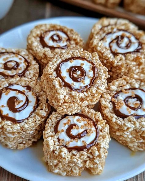 🍫 S'mores Rice Krispies Treats Pinwheels 🍫 These S'mores Rice Krispies Treats Pinwheels are a fun twist on the classic treat, combining the flavors of s'mores into a delightful rolled-up snack! Ingredients: 3 tablespoons unsalted butter 1 package (10 oz) mini marshmallows 6 cups Rice Krispies cereal 1 cup graham cracker crumbs 1 ½ cups mini chocolate chips 1 jar (7 oz) marshmallow fluff Instructions: Prepare the Pan: Line a large baking sheet with parchment paper. Make the Rice Krispies ... Rice Krispies Cereal, Rice Krispies Treats, Krispies Treats, Marshmallow Fluff, Rice Krispie, Mini Marshmallows, Graham Cracker Crumbs, Cute Desserts, Graham Cracker