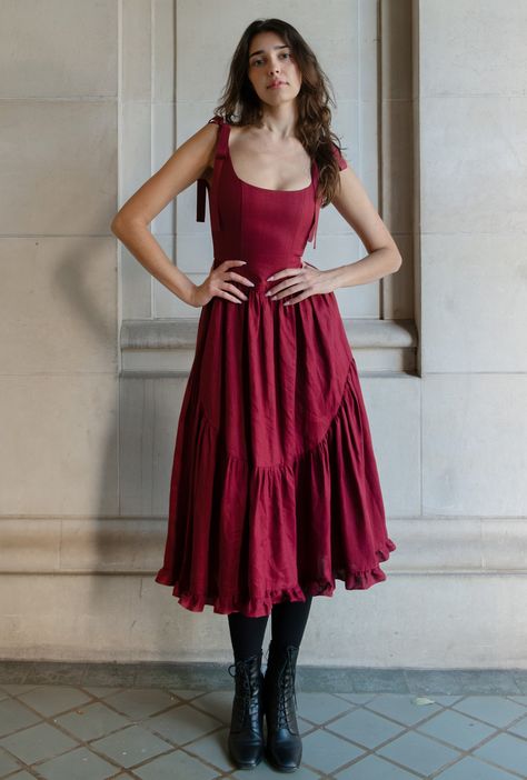 ready to ship xx a truly special dress. with rich ribbon tie straps, a corset bodice, and sweeping ruffle hem the mirabelle dress is dramatic, romantic beauty at its best and one of our most popular styles. updated in a beautiful, show stopping burgundy red and made in a lightweight linen with a sateen finish that gives the linen a subtle dressy luster. a showstopper of a dress made for holiday gatherings, celebrations, or romantic getaways. details: pockets, of course! lined bodice with boning, Princess Dresses Casual, Red Christmas Gown, Christmas Wedding Guest Dress, Drop Waist Corset Dress, Corset Dress Aesthetic, Dress For Rectangle Body Shape, Bookish Costumes, Red Dress With Corset, Graduation Dress Red