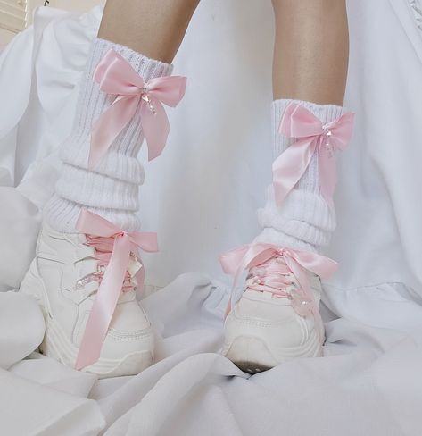 white leg warmers with pink bows. Each bow has a danggling chain with pearl and pink crystal heart beads. Model is wearing these leg warmers with chunky white platforms with pink ribbions as the shoe laces. There is a bunny charm with angel wings and heart charm on one shoe and a pink translucent my melody charm and a cat paw charm on the other shoe. Pastel Leg Warmers, Bow Leg Warmers, Shoes With Leg Warmers, Cute Pink Clothes, Leg Warmers Shoes, Cute Pastel Clothes, Kawaii Clothes Pastel, Leg Warmers Aesthetic, Cute Pink Shoes