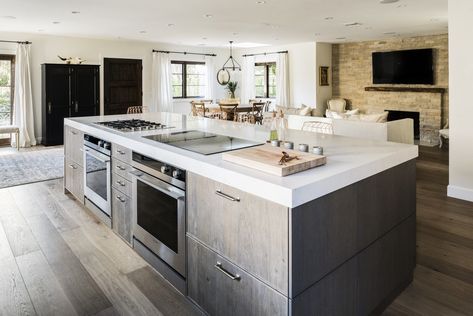 The gas and induction cooktop, along with the two ovens below, face the bar seating at the kitchen island, allowing Lefebvre to interact with his guests while preparing meals. Kitchen Island With Cooktop, Island With Stove, Kitchen Island With Stove, Island Cooktop, Wallpaper Tile, Unique Kitchen Design, Kitchen Black, Modern Kitchen Island, Kitchen Island With Seating