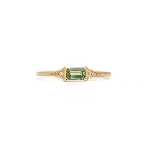 Exquisite and versatile, this dainty ring is a piece any lover of jewelry will adore. A vibrant green sapphire, nestled in Jennie Kwon's iconic deco setting, creates a captivating focal point. Perfectly suited for everyday wear, this ring can grace any finger or shine as a unique engagement option. Crafted in the U.S.A. from 14 karat gold, it features a 5 mm x 3 mm green sapphire and two shimmering 1.2 mm diamonds. Dainty Sapphire Engagement Ring, Dainty Emerald Engagement Ring, Dainty Gold Emerald Ring, Small Emerald Ring, Green Sapphire Ring Engagement, Senior Ring, Green Diamond Engagement Ring, Engagement Rings Green, Green Engagement Ring