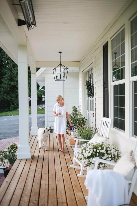 A favourite spot at our home is the front porch. It’s a beautiful place to sit in the morning and listen to the birds sing. In the evening,  the sun sets just right above and below the trees,  so Steve and I love to unwind from the day and watch the kids play up and down our long driveway. When… Long Verandah Ideas, Cottage Home Front Porch, Back Porch Inspiration Outdoor Living, White Farmhouse With Front Porch, Front Porch Ideas Large, Styling A Long Front Porch, Front Porch Bench Styling, Front Porch On White House, Traditional Porch Ideas