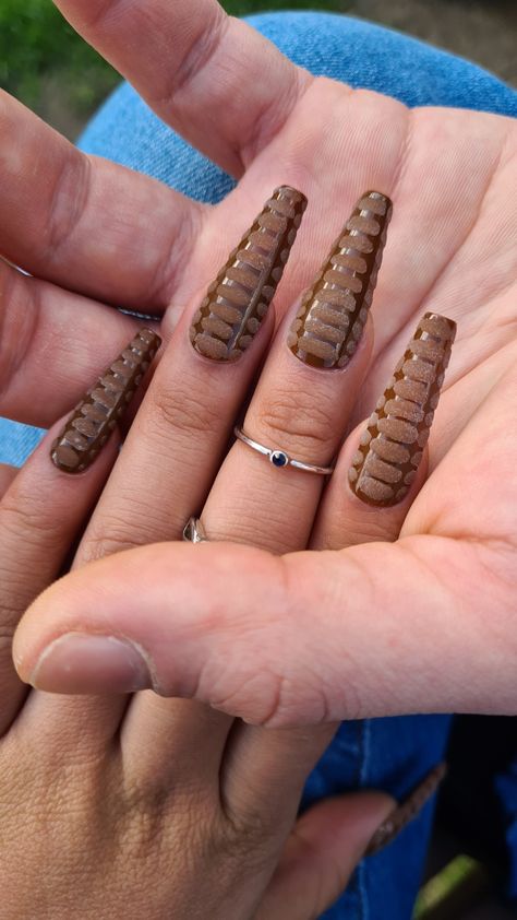 A man's hand holding a lady's hand to show off her nails. The nails are long coffin style with 3D crocodile skin design over a mocha color base. Crocodile Nails Brown, Nail Designs Crocodile, 3d Croc Print Acrylic Nails, Brown Crocodile Nails, Crocodile Skin Nails, Croc Print Acrylic Nails, Crocodile Nail Design, Crocodile Print Nails, Snakeskin Nails