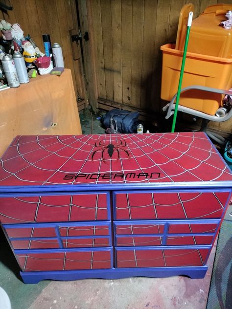 This is a custom Spiderman dresser I made for someones grandson .
I used carbon fiber vinyl wrap as a base to give it Spiderman's suit material then painted over it with red paint then buffed it with steel wool to thin 5he  red paint enough so you could see the carbon fiber   texture through the red paint and I also was going for the battle worn look I mean hero's battle you can't expect there suits to always look new right lol Spiderman Dresser, Toy Organization Living Room, Custom Spiderman, Ideas For Furniture, Man House, 21 Bday, Diy Kids Room Decor, Magical Room, Easy Painting Ideas