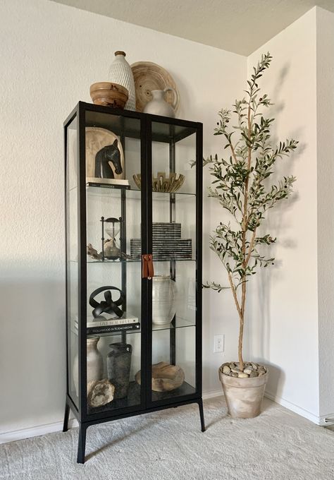 Modern Black Glass Cabinet, Black Display Cabinet Ikea, Ikea Black Display Cabinet, Black Glass Bookcase, How To Decorate The Top Of A Tall Cabinet, Black Display Cabinet Living Room, Glass Cabinet Decor Living Room, Decorate Glass Cabinets Living Room, Styling Curio Cabinet