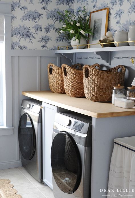 Light Blue Laundry Room with Shaker Pegs Makeover - Dear Lillie Studio Blue Shiplap Laundry Room, Laundry Room With Blue Cabinets, Pale Blue Laundry Room, Laundry Countertop Decor, Laundry Room With Paneling, Above Washing Machine Storage, Pretty Laundry Room Organization, Board Over Washer And Dryer, Laundry Room Shelf Styling