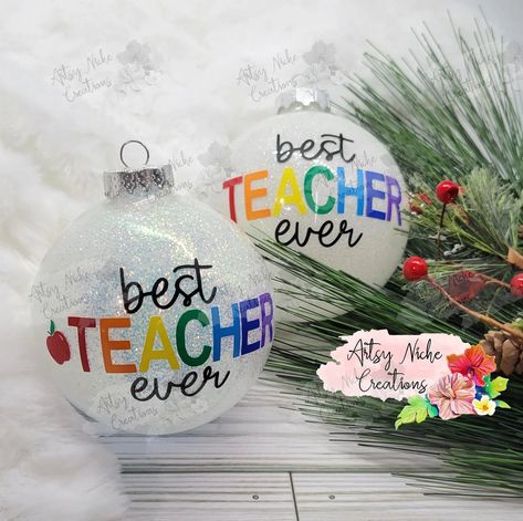 Spread cheer this holiday season by gifting your favorite teacher the Best Teacher Ever Christmas Ornament! Crafted with great attention to detail, this ornament celebrates the amazing efforts of teachers -- making a lasting impression on those who give and receive. Show your appreciation and make a statement with this special gift! 3" Glass Ornament Permanent vinyl lettering Comes with a white gift box This beautiful ornament uses 8 or or 9 colors for the vinyl on the outside, depending on opti Christmas Fillable Ornaments, Christmas Gifts For Coworkers Diy Ornaments, Disk Ornament Ideas, Christmas Teacher Gifts Cricut, Glitter Christmas Ornaments With Vinyl, Christmas Cricut Ornaments Diy, Christmas Ornament Vinyl, Christmas Diy Gifts To Sell, Personalized Glitter Ornaments