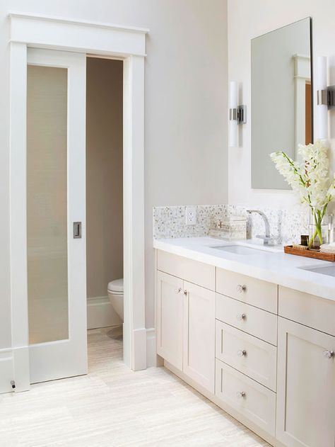 Calm & Comforting  One of the homeowner’s must-haves was a private toilet compartment, and with smart planning, they were able to incorporate one into this small 14x7-inch bathroom. The separate space includes extra towel storage, and the frosted-glass door admits light without sacrificing privacy. Floating mirrors flanked by linear sconces add to the room’s classic yet contemporary design. Toilette Design, Double Sinks, Toilet Room, Master Bath Remodel, Ensuite Bathroom, Pocket Door, Bathroom Remodel Designs, Bad Design, Bathroom Layout