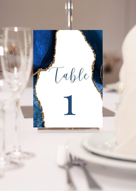 Add to your table setting with these printable blue, white and gold table numbers, perfect for your next event or DIY wedding. This table number template can be edited yourself using Canva. Print at home or take completed file to your local print shop and have them print. Print size is 5x7.  All the wording is editable. You will receive numbers 1-10. Simple instructions provided will give you the option to add on more numbers or print double sided. Details: blue, white and gold table numbers with agate design. Perfect addition to a DIY wedding, gala, birthday party, or however you choose to add to your events table setting decor. HOW IT WORKS: ♥ Once purchased, you will receive a link that will take you to Canva.com where you will be able to edit the template. You will be able to edit word Navy Blue Gold And White Party Decor, Blue White Gold Wedding, Blue And Gold Party, Wedding Table Settings Blue, White And Gold Wedding Themes, Event Table Settings, Navy Blue And Gold Wedding, Engagement Themes, Gala Decorations