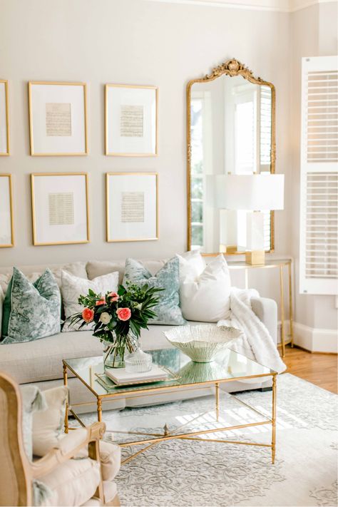 Living Room With Gold Coffee Table, Tall Gold Mirror Living Room, White Marble Coffee Table Decor, French Mirror Living Room, Lamp On Books, Antique White Living Room Walls, Gold Mirror Living Room Decor, Gold Coffee Table Decor, Gold Mirror Living Room