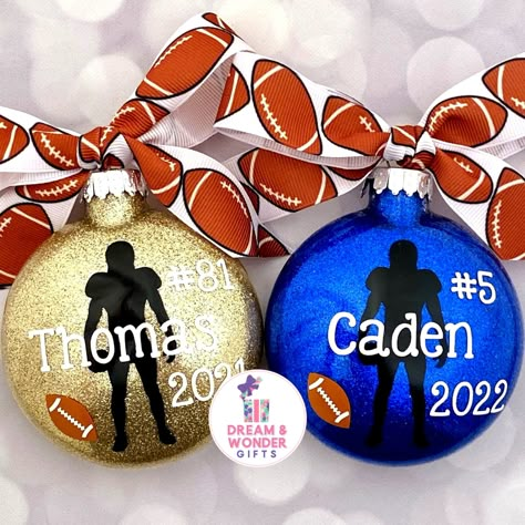 "Football Christmas Ornament Details: * Ornaments are glass M&M shaped discs, front is approximately 3-4\" inches with the bow and is approximately 1\" inch wide * Ornament will have white writing, football player silhouette in black, and a coordinating football patterned ribbon bow. If you would like team/school colors, please leave colors in the Personalization Box when entering Name and our designers will do our best to accommodate and capture your vision! * Ornament comes in white box ready Football Team Ornaments Diy, Football Theme Christmas Gifts, High School Christmas Ornaments, School Spirit Ornaments Diy, Diy Football Ornaments Ideas, Diy Vinyl Ornaments, Diy Football Ornaments, Personalized Ornaments Vinyls, Cricut Christmas Ornaments Ideas