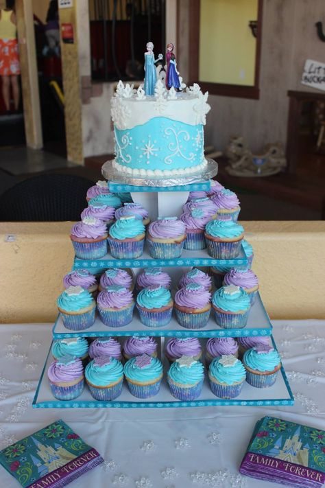 Frozen Party Cake Ideas, Frozen Cupcake Design, Elsa Birthday Cupcake Cake, Frozen Cake With Cupcakes, Frozen Birthday Party Cake Cupcakes, Anna And Elsa Cupcakes, Frozen Birthday Cake And Cupcakes, Frozen Birthday Cupcake Cake, Frozen Cake And Cupcakes