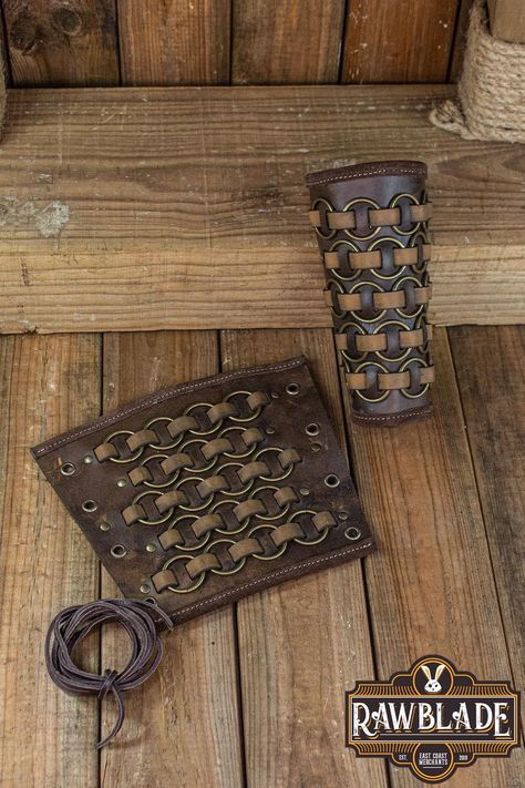 Introducing our Fighter Bracers, a formidable pair of leather armguards that exude the spirit of the medieval warrior. These bracers, adorned with metal rings intricately woven into leather strips, offer both protection and style, making them an essential accessory for LARP, historical reenactment, rennaisance fairs, and medieval events. Part of our esteemed Fighter product series, these bracers are meticulously crafted from high-quality leather, ensuring durability and reliability on the battle Armor Craft, Arm Guards, Medieval Aesthetic, Historical Reenactment, Leather Armor, Leather Projects, Fantasy Clothing, Diy Creative, Larp