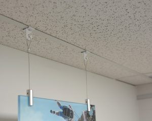 Product Spotlight: The Clever, Yet Simple Way To Hang Objects From Drop-Ceilings | Hang It Up Systems Art Hanging From Ceiling, Projector Shelf, Drop Down Ceiling, Art Hanging System, Drop Ceilings, Ceiling Hangers, Vbs 2023, Ceiling Grid, Drop Ceiling