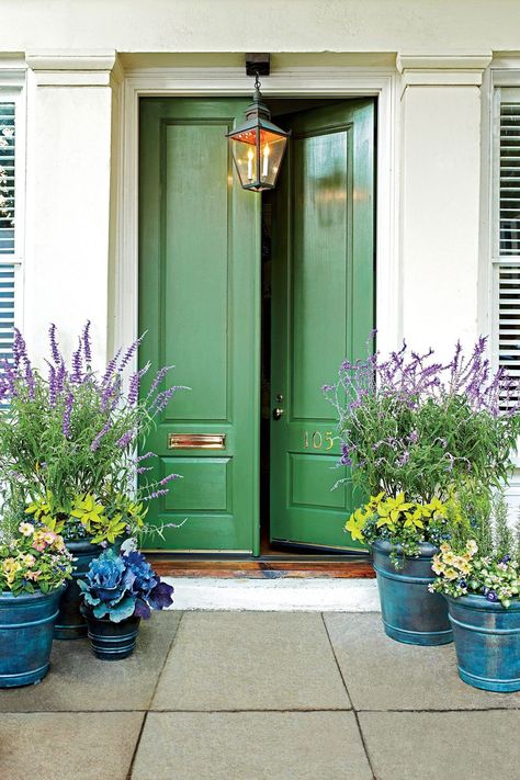 Jazz up your front door with a fresh coat of paint. Here are our favorite front door colors for a warm welcome. #frontdoorinspo #colorfulhome #southernhome #homedesign #frontdoor Coral Front Doors, Bold Front Door Colors, Bold Front Door, Green Front Door, Front Door Planters, Veranda Design, Yellow Front Doors, Indoor Paint, Door Planter