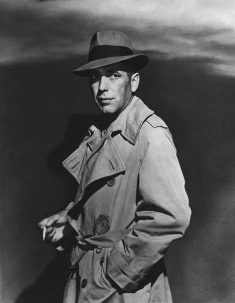 Humphrey Bogart in his portrayal of Rick Blaine in the film "Casablanca," wearing his iconic trench coat and Fedora. Humphrey Bogart, A Man, Trench Coat