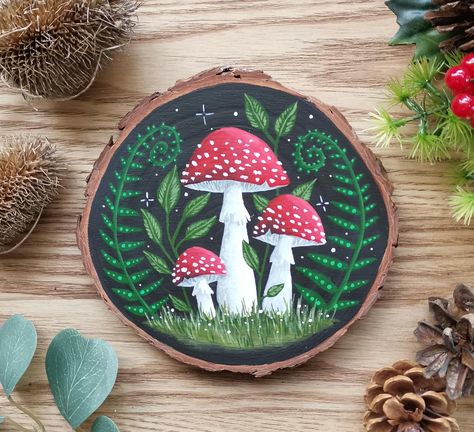 Hand painted mushroom wood slice with a black background. This wall plaque is a delightful way to bring some original artwork into your home.  Lovingly hand painted on natural wood using gouache paints and sealed with a waterbased matt varnish. There's also a brass D ring on the back to hang it on your wall. Approx 14cm x 13.5cm This is an original piece of art and is signed and dated on the back.  Please note colours may vary slightly due to variations in monitor and camera settings Indoor use Mushroom Wood Painting, Art On Wood Painting, Wood Slice Painting Ideas, Painting On Wood Slices, Mushroom Painting Ideas, Mushroom Paintings, Artsy Christmas, Plaque Ideas, Camera Painting