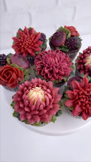 Leslie Vigil on Instagram: "Protea, Dahlia, Roses, Ranunculus + Blackberries🌹🍇🥀 I could have just bought actual blackberries for these cupcakes, but I piped them instead. Is it extra work? Yes, it is. But there’s something about being a little bit cheeky and ~maybe~ possibly fooling the unassuming person who might try to sneak a blackberry off one of the cupcakes. I find that idea very gratifying. It’s like a little treat for me 😊 . . . . . #buttercreambotanicals #buttercreamflowers #bl Thistle Cupcakes, Dahlia Cupcakes, Aesthetic Desserts, Protea Wedding, Cupcake Shop, Icing Piping, Cupcake Shops, Extra Work, Piping Icing