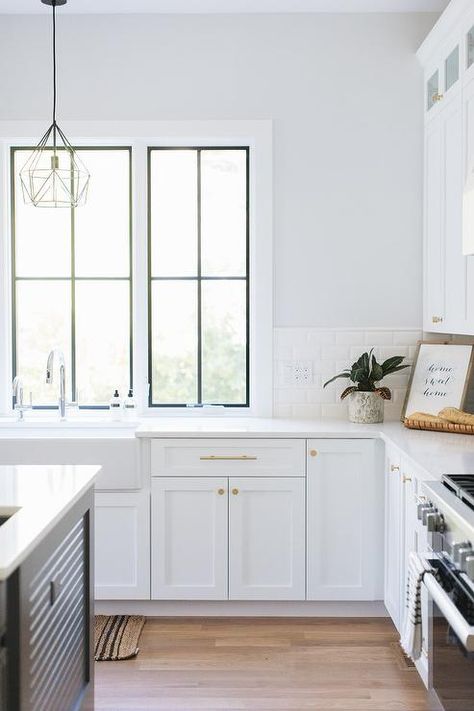 A white kitchen wall, half covered in white subway backsplash tiles, frame windows positioned over a farmhouse sink matched with a polished nickel gooseneck faucet. Subway Tile Kitchen Wall, Trendy Kitchen Tile, Kitchen Windows, Farmhouse Sinks, White Tile Backsplash, White Wall Tiles, Farmhouse Kitchens, Subway Tile Kitchen, White Backsplash