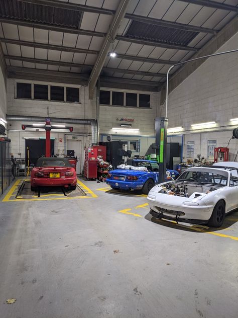 A quick snap of 3 MX-5s. The white and blue are racing cars. Car Shop Aesthetic, Car Warehouse, Garage Aesthetic Car, Car Garage Workshop Aesthetic, Jdm Garage, Detaling Car Garage, Car In Mechanic Shop, Mechanical Workshop, Mechanic Shop