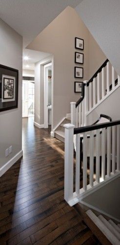 White banister poles with a dark wood handrail and matching stained floor make this space look brilliant, beige/grey walls are the perfect colour to complement the wood White Banister, Hallway Flooring, Dark Wood Floors, Floor Colors, Home Decor Online, Entry Way, Hardwood Flooring, Grey Walls, My Dream Home