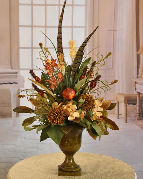 A unique floral design perfect for smaller spaces, requiring  height and  lots of style.  Set this gorgeous design on  a mantle, dresser, end table, desk or shelf. Just to name a few.  Created with fern, heather, pomegranate, foliage, grasses, and pods in warm tan and rust tones. Fall Grass Arrangements, Fall Feather Centerpieces, Fall Floral Arrangements For Church, African Floral Arrangements, Fall Flower Centerpiece, Large Fall Floral Arrangements, Fall Floral Arrangements Wedding, Masculine Floral Arrangements, Fall Vase Arrangements